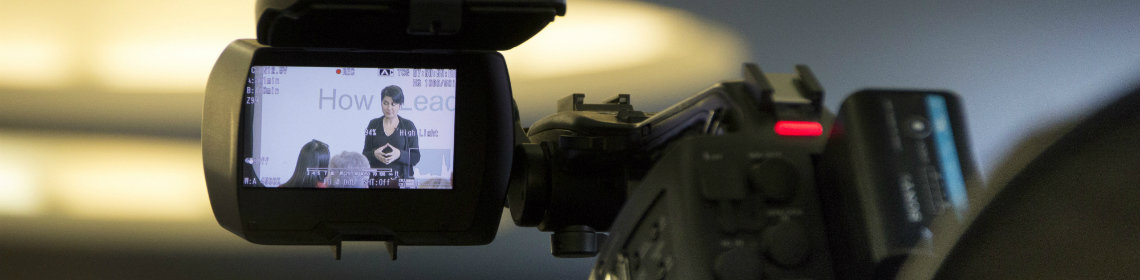 female presenter seen through screen of a video recorder