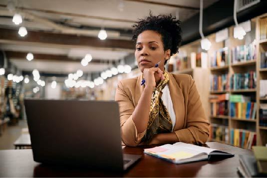 Women in library looking at laptop