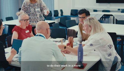 People sat around a meeting table in a workplace