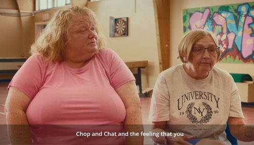 Two women in a community centre talking 