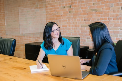 Two women sat at a table talking to each other