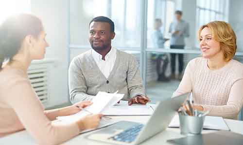 Three people in a meeting room 