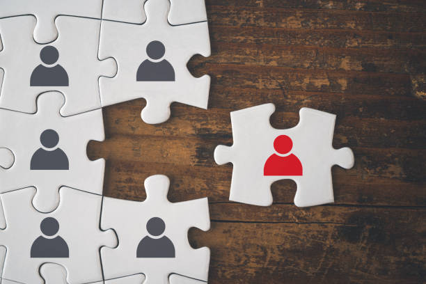 Jigsaw on a table with a red piece of the jigsaw representing the ideal candidate