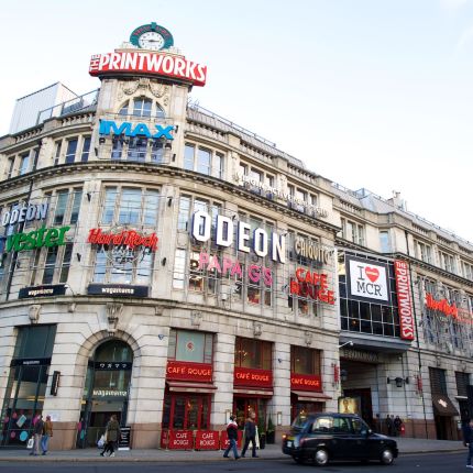 Exterior shot of printworks, covered in brand names.