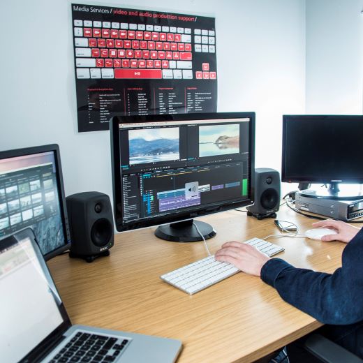 Man at desk, editing a video.