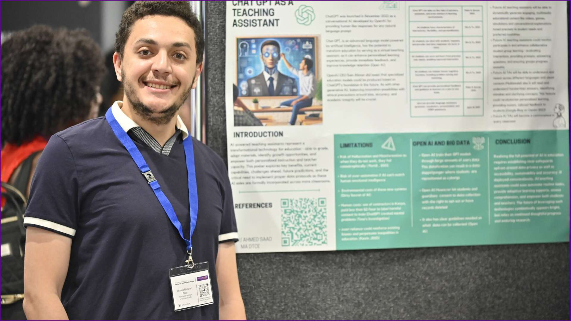 Attendee posing next to poster stand