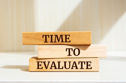 A block of wood saying 'time to Evaluate'